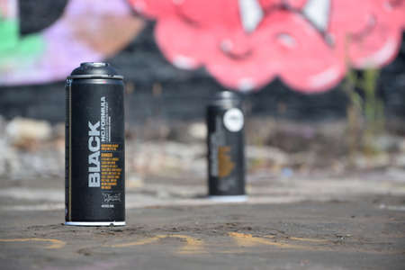 KHARKOV, UKRAINE - AUGUST 16, 2020: Used Montana black aerosol spray cans against graffiti paintings. MTN or Montana-cans is manufacturer of high pressure spray paint goodsのeditorial素材