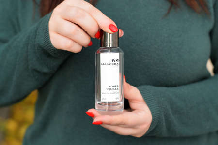 KHARKOV, UKRAINE - OCTOBER 16 2020: Young girl holds Mancera roses vanille perfume bottle. Mancera is a french perfume brandのeditorial素材