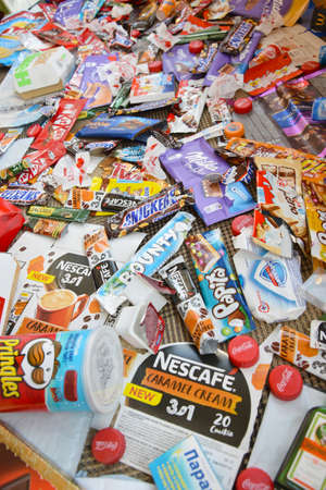 KHARKOV, UKRAINE - APRIL 8, 2020: Many wrappings and cans from used products by famous worldwide brands. Pattern of trash of various colors and materialsのeditorial素材