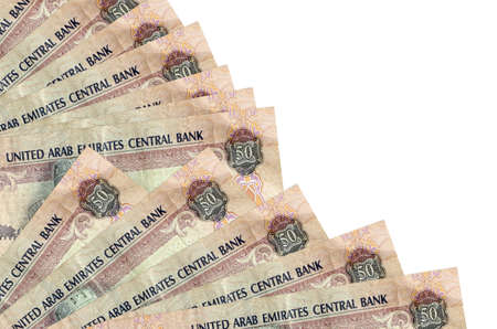 50 UAE dirhams bills lies isolated on white background with copy space stacked in fan close up....