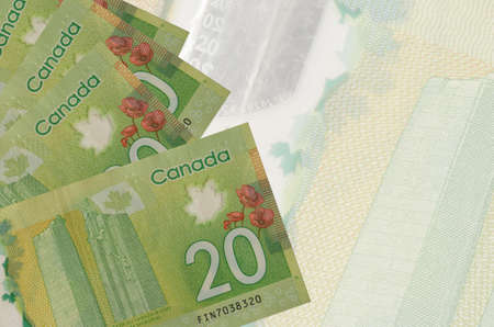 20 Canadian dollars bills lies in stack on background of big semi-transparent banknote. Abstract business background with copy spaceの写真素材