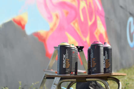 KHARKOV, UKRAINE - AUGUST 16, 2020: Used Montana black and hardcore aerosol spray cans against graffiti paintings. MTN or Montana-cans is manufacturer of high pressure spray paint goodsのeditorial素材