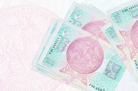 100 Czech korun bills lies in stack on background of big semi-transparent banknote. Abstract...