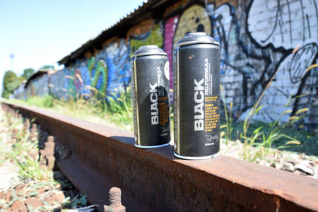 KHARKOV, UKRAINE - AUGUST 16, 2020: Used Montana black aerosol spray cans against graffiti paintings. MTN or Montana-cans is manufacturer of high pressure spray paint goodsのeditorial素材