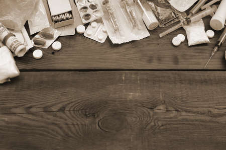 A lot of narcotic substances and devices for the preparation of drugs lie on an old wooden table....