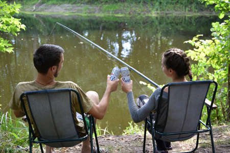 KHARKOV, UKRAINE - AUGUST 22 2020: Boy and girl cheers with Budweiser Lager Alcohol Beer can during fishing. Budweiser is Brand from Anheuser-Busch Inbev most popular in Americaのeditorial素材