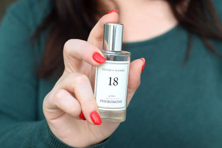 KHARKOV, UKRAINE - OCTOBER 16 2020: Young girl holds Federico Mahora 18 parfum pheromone bottle. Federico Mahora is perfume production by FM World LLC groupのeditorial素材