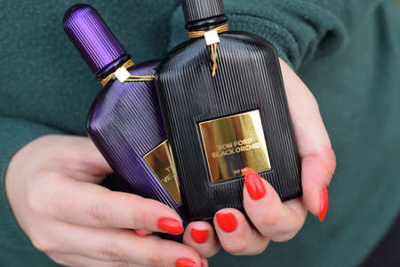 KHARKOV, UKRAINE - OCTOBER 16, 2020: Girl holds Tom Ford velvet orchid and Black orchid fragrance perfume bottles. Tom Ford is American fashion designer launched his eponymous luxury brand in 2006のeditorial素材