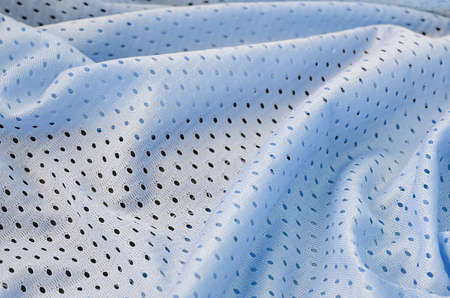 Blue mesh sport wear fabric textile pattern background. Blue color football jersey clothing fabric...