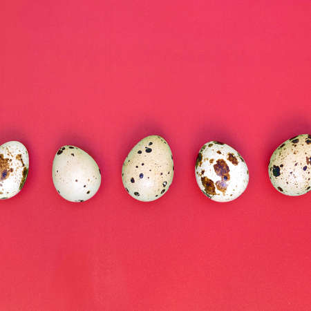 Quail eggs on a light red surface, top view, empty place for text, recipe
