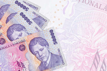 50,000 Romanian leu bills lies in stack on background of big semi-transparent banknote. Abstract business background with copy spaceの写真素材
