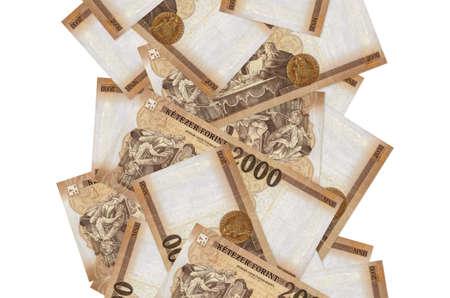 2000 Hungarian forint bills flying down isolated on white. Many banknotes falling with white copy...