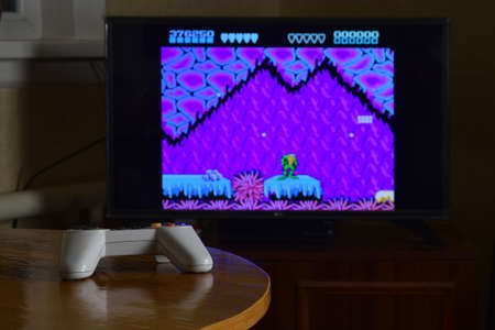 KHARKOV, UKRAINE - NOVEMBER 12, 2020: Dendy video game controller on table with Battletoads game on...