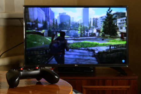 KHARKOV, UKRAINE - NOVEMBER 12, 2020: Video game controller Gamesir g3s on table with The last of us...