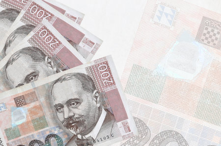 200 Croatian kuna bills lies in stack on background of big semi-transparent banknote. Abstract business background with copy spaceの写真素材