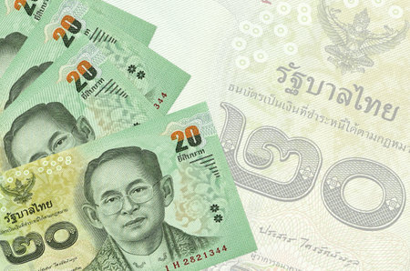 20 Thai Baht bills lies in stack on background of big semi-transparent banknote. Abstract business...