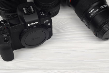 KHARKOV, UKRAINE - NOVEMBER 23, 2020: Canon EOS R photocamera and mount adapter EF - EOS R with Canon 105mm f2.8 and Sigma 24-105 f4 Art lenses on white wooden tableのeditorial素材