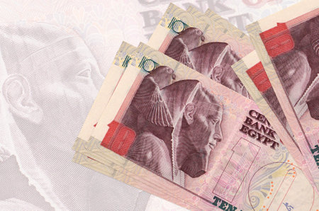 10 Egyptian pounds bills lies in stack on background of big semi-transparent banknote. Abstract presentation of national currency. Business conceptの写真素材