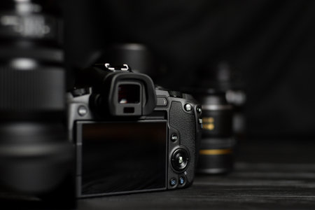 KHARKOV, UKRAINE - NOVEMBER 23, 2020: Canon EOS R photocamera with Canon lenses on black table....