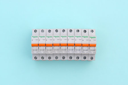 KHARKOV, UKRAINE - OCTOBER 29, 2020: Schneider electric circuit breakers on light blue background. Schneider Electric is a French power engineering company, a manufacturer of electric equipmentのeditorial素材
