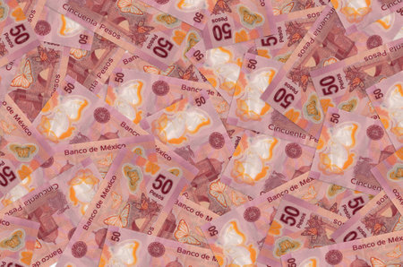 50 Mexican pesos bills lies in big pile. Rich life conceptual background. Big amount of moneyの写真素材
