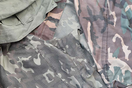 Camouflage background texture as backdrop for military service design projects. Back side of...