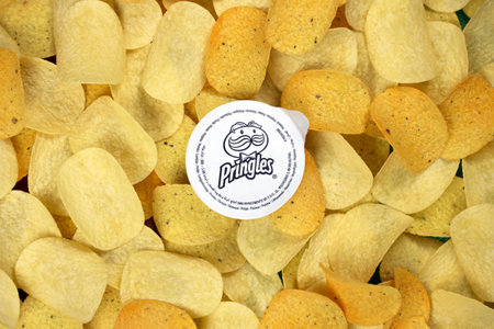 KHARKOV, UKRAINE - NOVEMBER 23, 2020: Pringles logo on paper membrane on many orange Pringles potato...