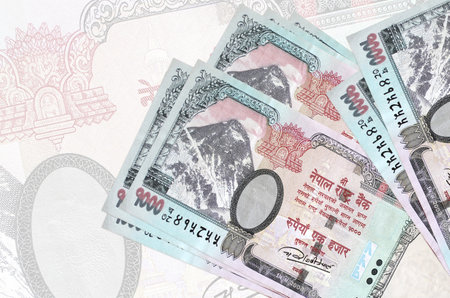 1000 Nepalese rupees bills lies in stack on background of big semi-transparent banknote. Abstract presentation of national currency. Business conceptの写真素材