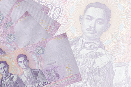 500 Thai baht bills lies in stack on background of big semi-transparent banknote. Abstract business...