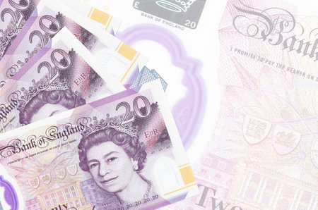 20 British pounds bills lies in stack on background of big semi-transparent banknote. Abstract...