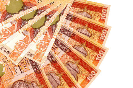 100 Sri Lankan rupees bills lies isolated on white background with copy space stacked in fan shape...