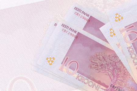 10 Estonian kroon bills lies in stack on background of big semi-transparent banknote. Abstract...