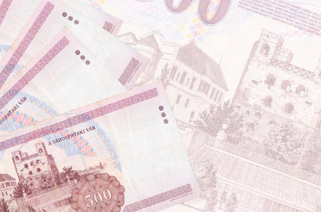 500 Hungarian forint bills lies in stack on background of big semi-transparent banknote. Abstract...