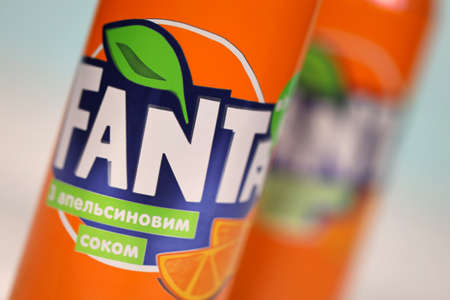KHARKOV, UKRAINE - DECEMBER 8, 2020: Aluminum cans of Fanta soft drink on white wooden table. Fanta...