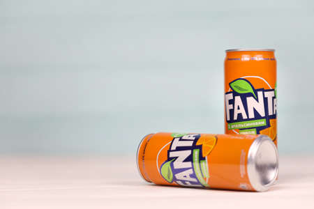 KHARKOV, UKRAINE - DECEMBER 8, 2020: Aluminum cans of Fanta soft drink on white wooden table. Fanta...