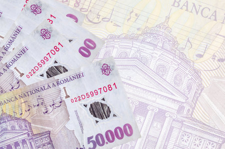 50,000 Romanian leu bills lies in stack on background of big semi-transparent banknote. Abstract business background with copy spaceの写真素材