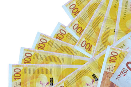 100 Israeli new shekels bills lies in different order isolated on white. Local banking or money...