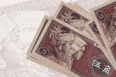 5 Chinese yuan bills lies in stack on background of big semi-transparent banknote. Abstract presentation of national currency. Business conceptの写真素材