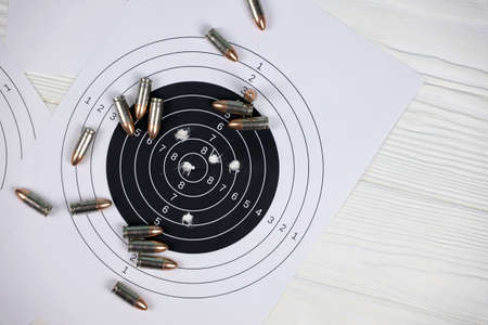 Many bullets with shooting targets on white table in shooting range polygon. Training for aiming and shooting accuracyの写真素材