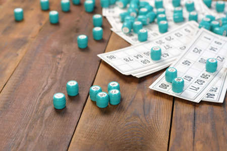 Many barrels with numbers and cards for lotto or russian bingo table game on wooden surface. Russian...