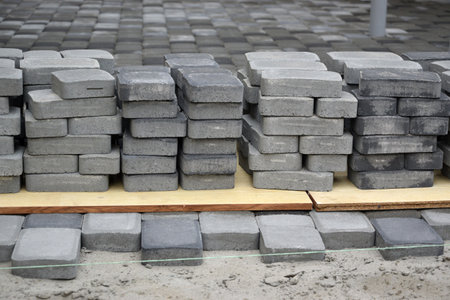 Rows of gray and dark gray walkway slab lying outdoors. Material for Paving Slabs by mosaic in progress. Cobblestone installation processの写真素材