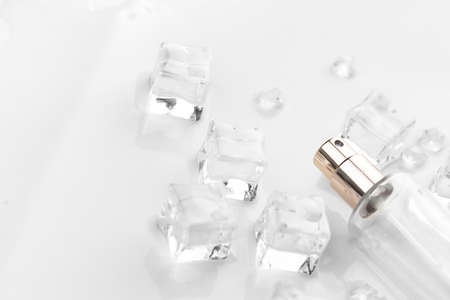 Female perfume bottle, objective photograph of perfume bottle in ice cubes and water. view from...