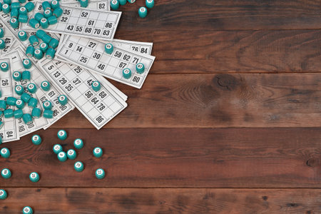 Many barrels with numbers and cards for lotto or russian bingo table game on wooden surface. Russian lotto has similar rules to classical worldwide bingo gameの写真素材