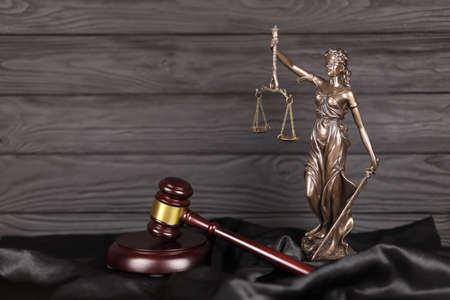 The Statue of Justice - lady justice or justitia the Roman goddess of Justice. Statue on brown book...