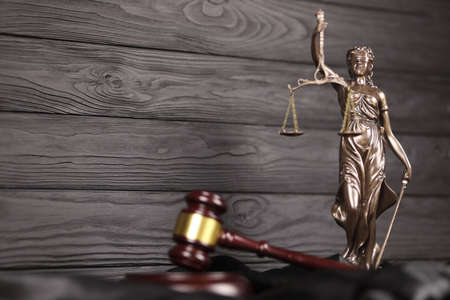 The Statue of Justice - lady justice or justitia the Roman goddess of Justice. Statue on brown book...