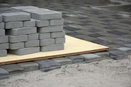 Rows of gray and dark gray walkway slab lying outdoors. Material for Paving Slabs by mosaic in progress. Cobblestone installation processの写真素材