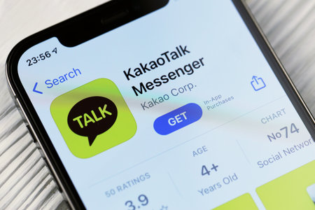 KHARKOV, UKRAINE - MARCH 5, 2021: KakaoTalk Messenger icon and application from App store on iPhone 12 pro display screen on white wooden tableのeditorial素材