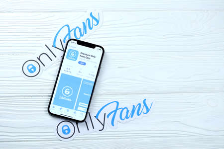 KHARKOV, UKRAINE - MARCH 5, 2021: Onlyfans icon and application from App store on iPhone 12 pro display screen on white wooden tableのeditorial素材
