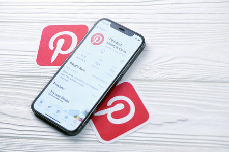 KHARKOV, UKRAINE - MARCH 5, 2021: Pinterest icon and application from App store on iPhone 12 pro display screen on white wooden tableのeditorial素材