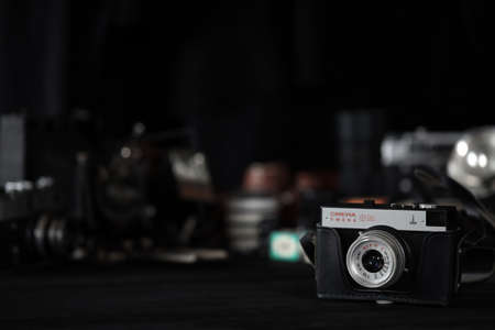 KHARKOV, UKRAINE - APRIL 27, 2021: Smena 8m Film photo camera and another old retro photo equipment on black wooden table in photographer darkroom. Photographic gear from soviet union timesのeditorial素材